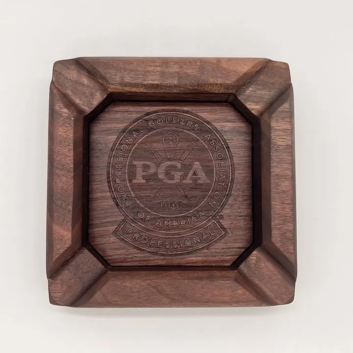 Top view of a square walnut ashtray with an engraved PGA seal in the center